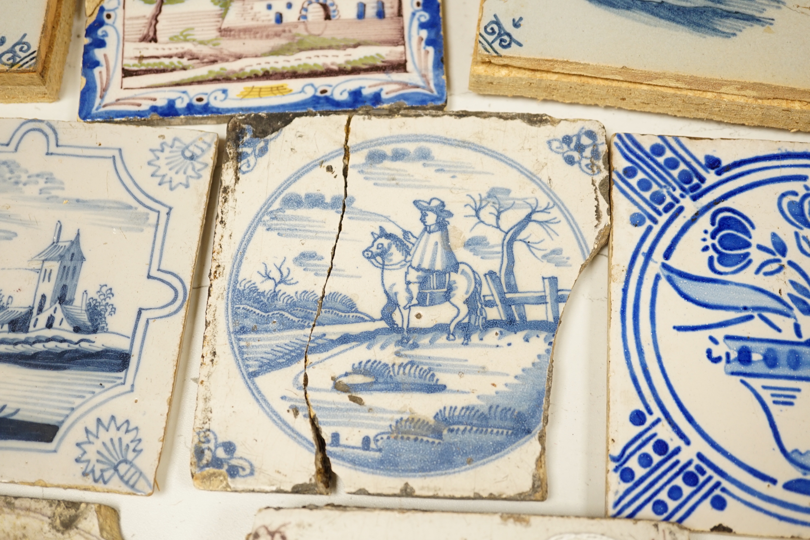 A group of Delft tiles including two polychrome examples and three decorated with ships, 18th/19th century, approximately 12.5cm x 12.5cm (a.f.)